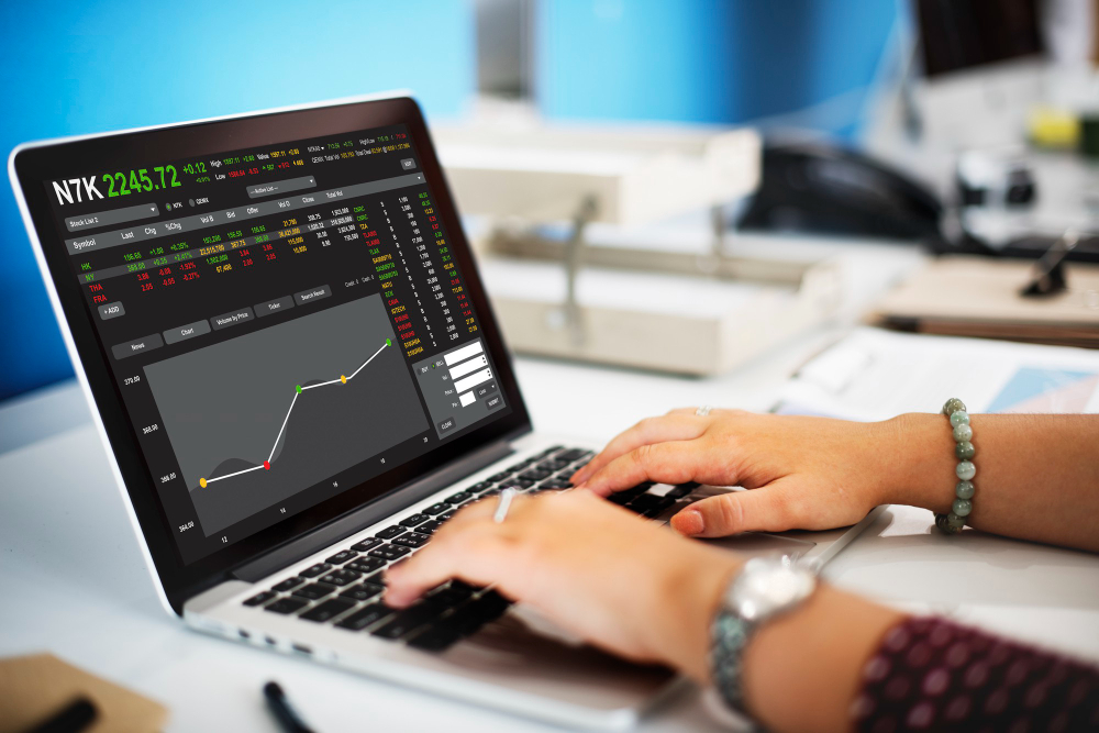 Trader analyzing market charts on a laptop with reward to risk ratio examples applied in forex trading